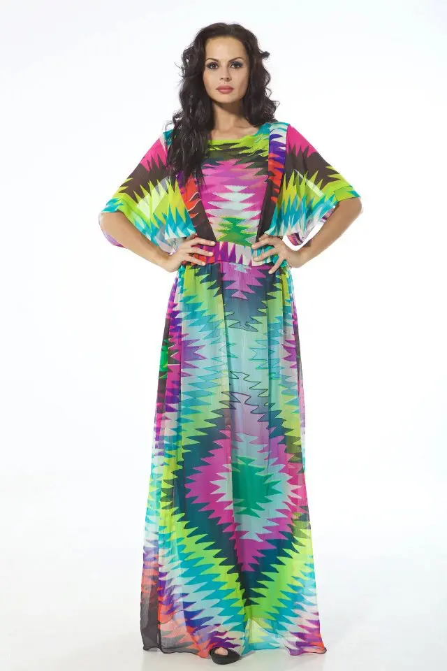 Model wearing a silk chiffon kaftan in exaggerated ikat print with body lining, kimono sleeves, and frills from shoulder to waist.